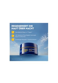 Blue jar with a gold accent lid labeled "Q10 Anti-Falten Power," featuring rounded edges and a glossy finish. Background is light blue.