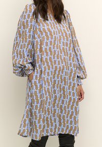 Dlouhý rukáv pouzdrové šaty ve světle modré a hnědé geometrické vzory, s uvolněným střihem, kapsami a nařasenými detaily na rukávech.