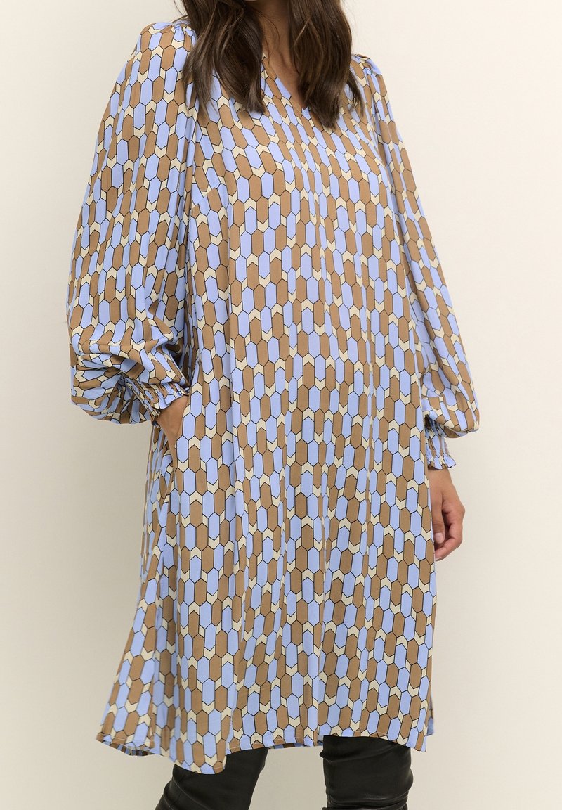 Dlouhý rukáv pouzdrové šaty ve světle modré a hnědé geometrické vzory, s uvolněným střihem, kapsami a nařasenými detaily na rukávech.