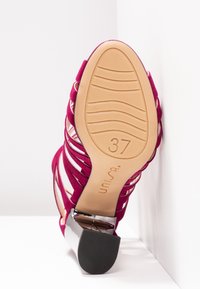Sandale à talons roses à brides pour femme de taille 37 montrant une semelle texturée et un talon bloc noir sur fond blanc.