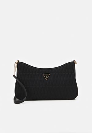 Black quilted shoulder bag with slim strap and gold-tone triangular Guess logo centered on front.