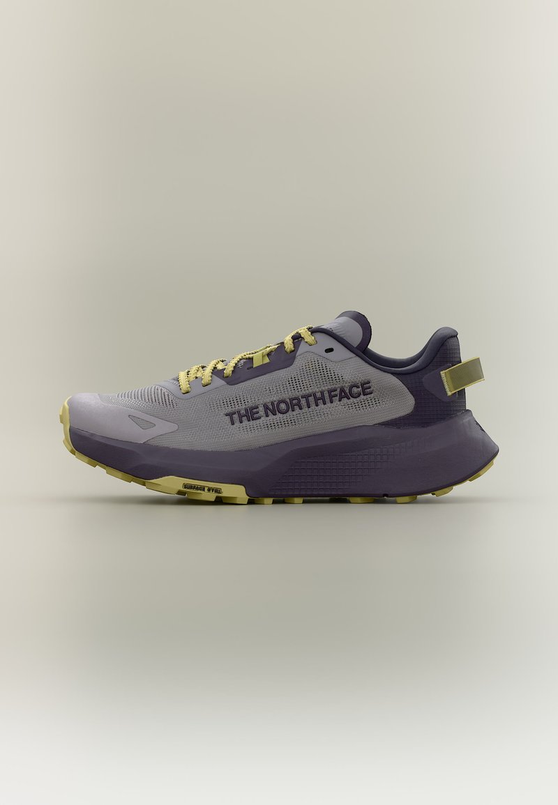Αθλητικό παπούτσι σε ανοιχτό γκρι και σκούρο μωβ με κίτρινες κορδόνια και επισημάνσεις στη σόλα, με το λογότυπο "The North Face" στο πλάι.