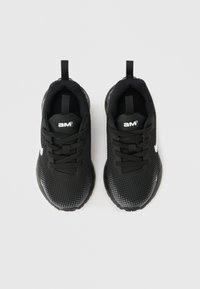 Ζευγάρι μαύρα αθλητικά παπούτσια με λευκό λογότυπο, σχέδιο με κορδόνια και θηλιές στο πίσω μέρος, φωτογραφημένα απ ό πάνω σε απλό φόντο.