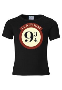 Black short-sleeve t-shirt featuring a circular graphic with a light yellow background, red border, and the text “PLATFORM 9¾” in bold black font.
