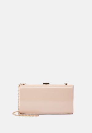 Pochette beige rectangulaire brillante avec une bandoulière chaîne dorée et un petit fermoir métallique sur le dessus, placée sur un fond blanc.