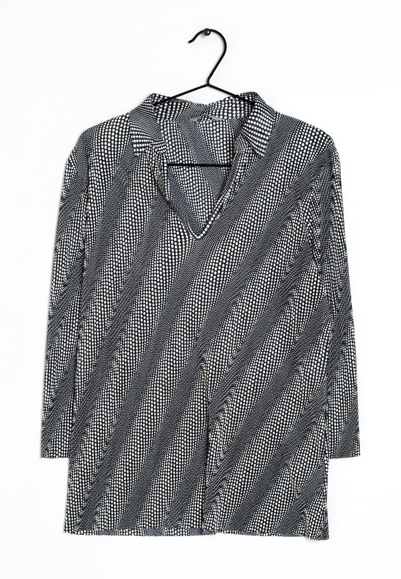 Schwarz-weiße Langarmbluse mit Kragen, die diagonale Streifen mit unterschiedlichen gepunkteten Mustern und ein V-Ausschnitt-Design aufweist.