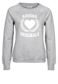 Grå Adidas Originals sweatshirt med vit hjärta och lagerkransdesign på framsidan, rund hals, och långa ärmar.