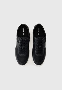 Zwarte leren sneakers met een gladde textuur, met een ronde neus, vetersluiting en een contrasterende witte rubberen zool. Merken zichtbaar aan de binnenkant.