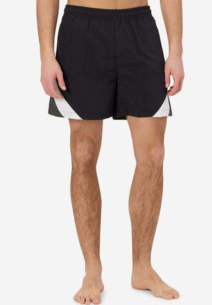 Pantaloni da bagno neri con pannelli laterali bianchi, vita elastica e tessuto leggero. Design di lunghezza media fino alla coscia. Nessun motivo o decorazione visibile.