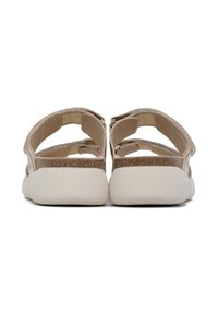 Sandali beige con una suola bianca testurizzata e ammortizzata. Presentano due cinturini regolabili e un materiale superiore liscio, con cuciture visibili.