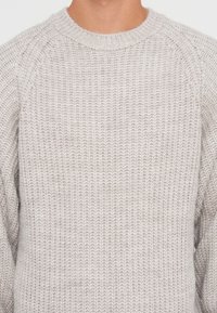 Light gray knit sweater with a textured finish, featuring a round neck and raglan sleeves, made from a soft, medium-weight yarn.