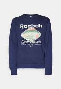 Mörkblå sweatshirt med rund hals, ribbade muddarmar, och en grafisk design av en tennisbana med texten "Reebok Court Classics".