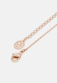Collier en chaîne en or rose avec un pendentif octagonal texturé et un fermoir à mousqueton. La chaîne présente un mélange de maillons et des détails délicats.