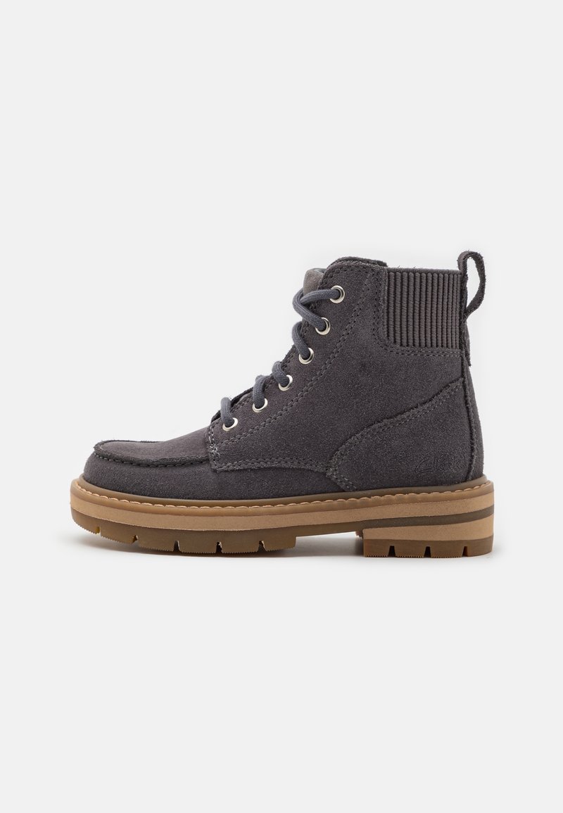 Bottine à lacets en daim gris foncé avec col rembourré, languette de traction et semelle épaisse en caoutchouc beige avec relief pour une meilleure adhérence.