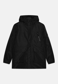 Chaqueta impermeable con capucha negra, cierre frontal con cremallera, puños elásticos y tres bolsillos frontales, incluido uno con cremallera en el pecho.