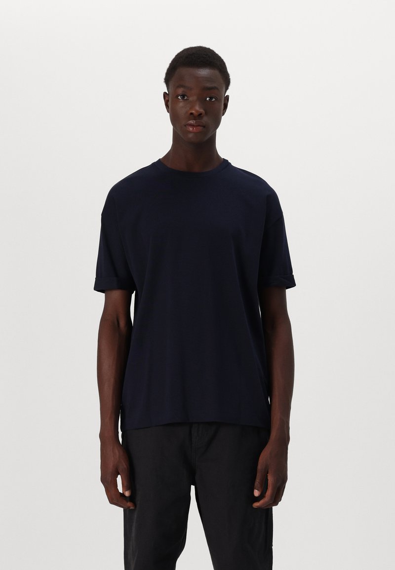 Tricou bleumarin cu manșetă scurtă, guler rotund și tivuri răsucite. Fabricat dintr-un material neted; croială lejeră, design minimalist.
