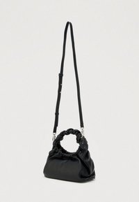 Musta pehmeästä nahasta valmistettu laukku, jossa on solmittu kahva ja säädettävä olkahihna. Muoto on pyöreä ja siinä on kerätty kuviointi.