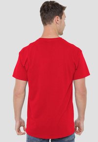 Red cotton t-shirt with a round neckline and short sleeves, featuring a plain back without patterns or graphics.