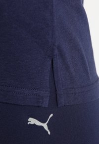 Námořnická bavlněná tričko s bočním rozparkem, tvořená stříbrným logem Puma na dolním lemu. Měkká textura, neformální design.