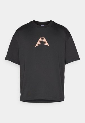 Černé tričko s krátkými rukávy z bavlněné směsi, na hrudi s růžovým geometrickým logem. Kulatý výstřih, volný střih.