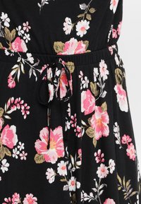 Țesătură neagră cu un model floral în nuanțe de roz, alb și bej. Dispune de un talie cu șnur și o textură moale, potrivită pentru purtatul casual.