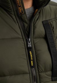 Olivgrüne Daunenjacke mit gesteppter Textur, ausgestattet mit einem schwarzen Reißverschluss und einem gelben "PME Legend"-Label. Enthält einen grauen Innenkragen.