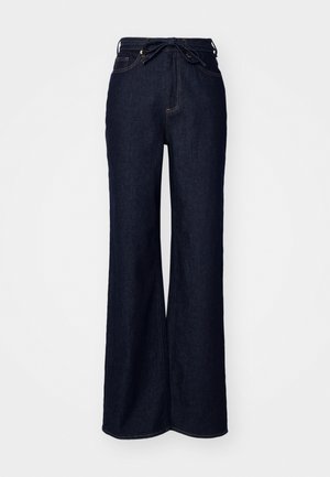 Jean large en denim bleu foncé, avec une taille haute, des poches avant et une fermeture à lacer à la taille.