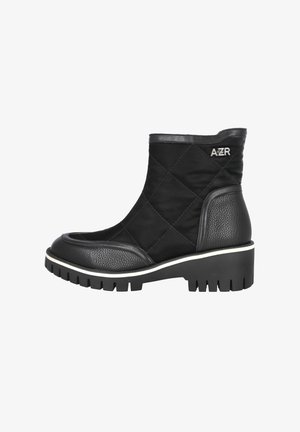 Botín negro hasta el tobillo hecho de tela acolchada con detalles de cuero, punta redonda y una suela gruesa y estriada con un borde blanco. Logo de AZR en el lateral.