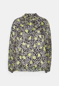 Blusa bianca e nera con un motivo floreale caratterizzato da fiori gialli brillanti. Tessuto morbido e leggero con colletto a fiocco e maniche lunghe.