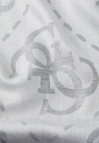 Heledhall hall, mille peene, peenedav logotiivi muster. Tekstuur on sujuv sisekujundusega, mis avab kudumise detaile.