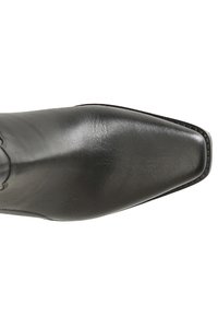 Scarpa in pelle nera con punta affusolata e superficie liscia, caratterizzata da cuciture dettagliate lungo il bordo e una suola in contrasto.