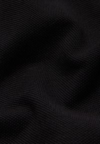 Czarna tkanina o teksturowanej powierzchni z prążkowanym wzorem, z delikatnymi falami i fałdami, podkreślająca swoją elastyczność i miękkość.