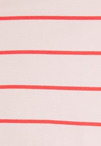 Randig tyg med horisontella röda linjer på en ljus rosa bakgrund, tillverkat av mjukt material med en slät textur.