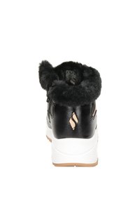 Retro del scarpe in materiale sintetico nero con colletto in finta pelliccia, suola intermedia bianca e un accento beige a forma di diamante vicino al tallone.