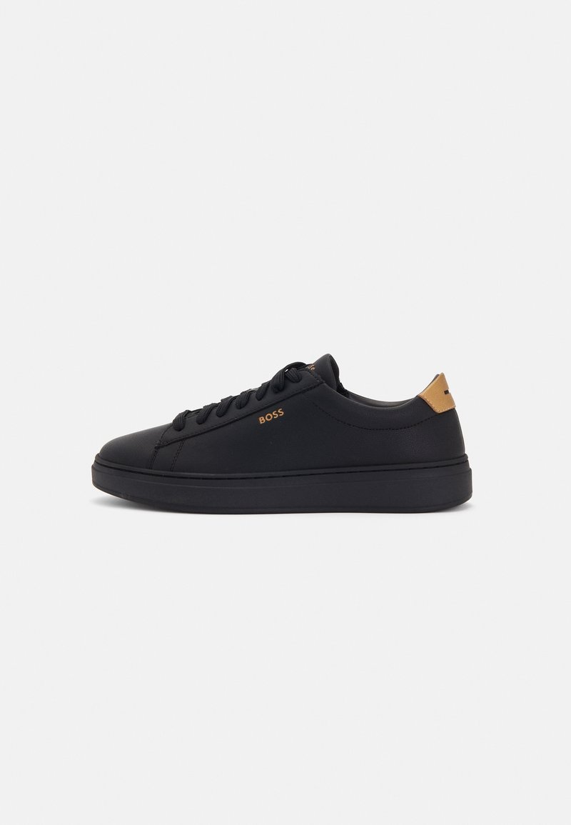 Baskets basses en cuir noir avec lacets noirs, languette de talon beige et petit logo "BOSS" doré sur le côté, vues de profil.