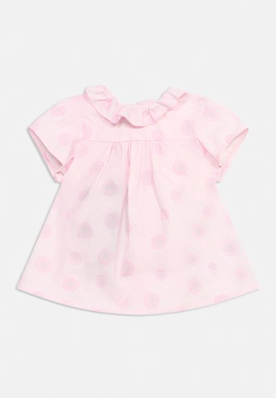 Vestito da bambina rosa chiaro con maniche corte, scollatura arricciata e motivo circolare discreto su tutto il tessuto.