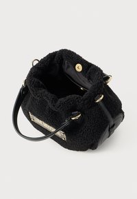 Small black fuzzy bucket bag with leather handles, gold hardware, and a "Love Moschino" logo plate on the front.