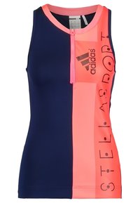 Adidas linnen med en marinblå och neonrosa färgblockdesign, dragkedja framtill och logotypdetaljer. Tillverkad av stretchigt, fukttransporterande material.