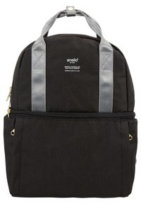 Sac à dos en tissu noir avec des bretelles grises, des détails de fermeture éclair dorés et une poche avant. Il présente un logo et un design simpliste.