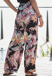 Wijdvallende broek gemaakt van lichtgewicht stof, met een levendig multicolor bloemenpatroon op een zwarte achtergrond. Elastische tailleband, losse pasvorm.