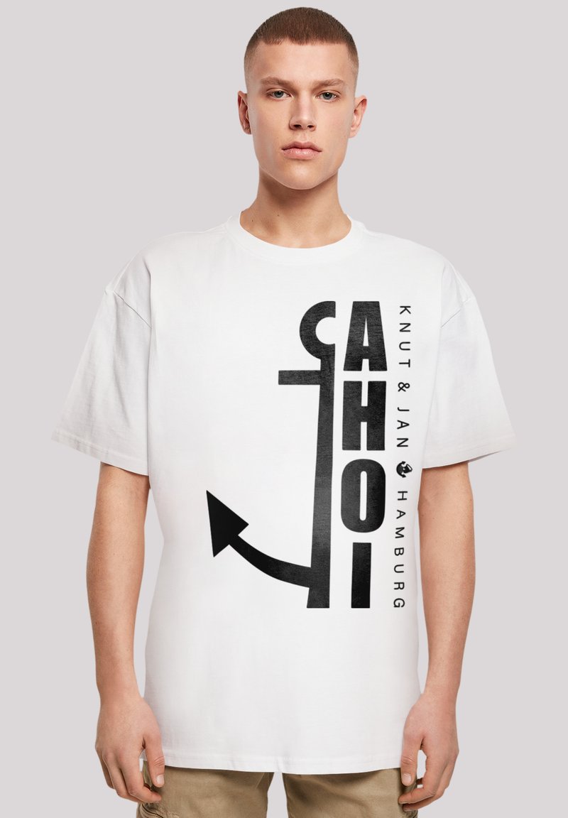 White cotton T-shirt featuring bold black text and an arrow graphic. The design includes "Knut & Jan Hamburg" along the side.