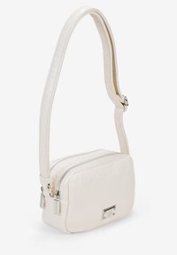 Bolso bandolera color crema hecho de material sintético texturizado. Presenta un cierre con cremallera, forma rectangular plana y correa ajustable.