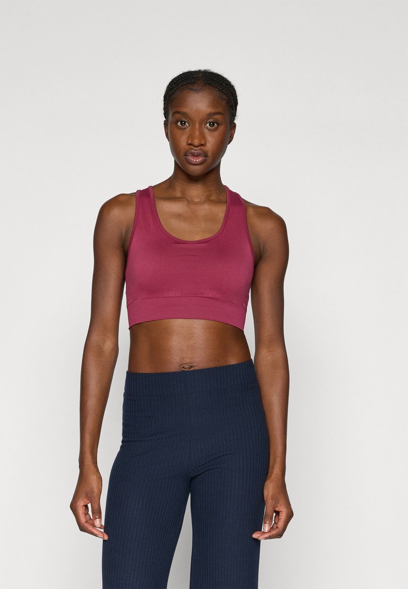 Burgundy cropped tank top dengan tali lebar dipadukan dengan legging bergaris navy. Tekstur halus dengan desain yang pas, cocok untuk pakaian aktif.
