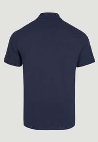Polo bleu marine uni à manches courtes avec col côtelé, vu de dos sur un fond neutre.