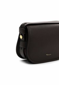 Braune Ledertasche zum Umhängen mit strukturiertem Finish, Klappenverschluss, goldenen Beschlägen und einem Markenlogo auf der Vorderseite. Kompakte und strukturierte Form.