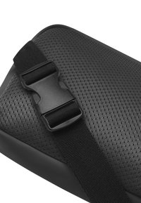 Svart strukturerad väska med ett mesh-yta, justerbar svart rem med en plastspänne, och en slät rundad kant.