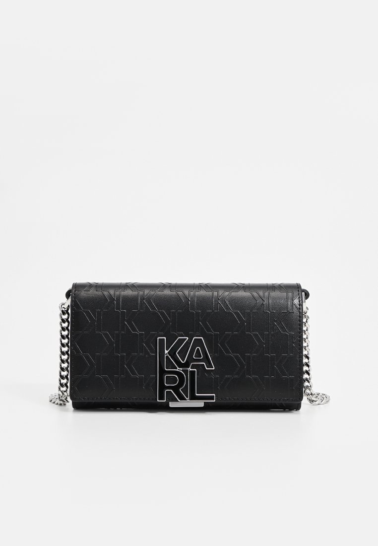 Sac bandoulière en cuir synthétique noir avec un motif texturé en K, chaîne argentée et un logo "KARL" bien en vue à l'avant.