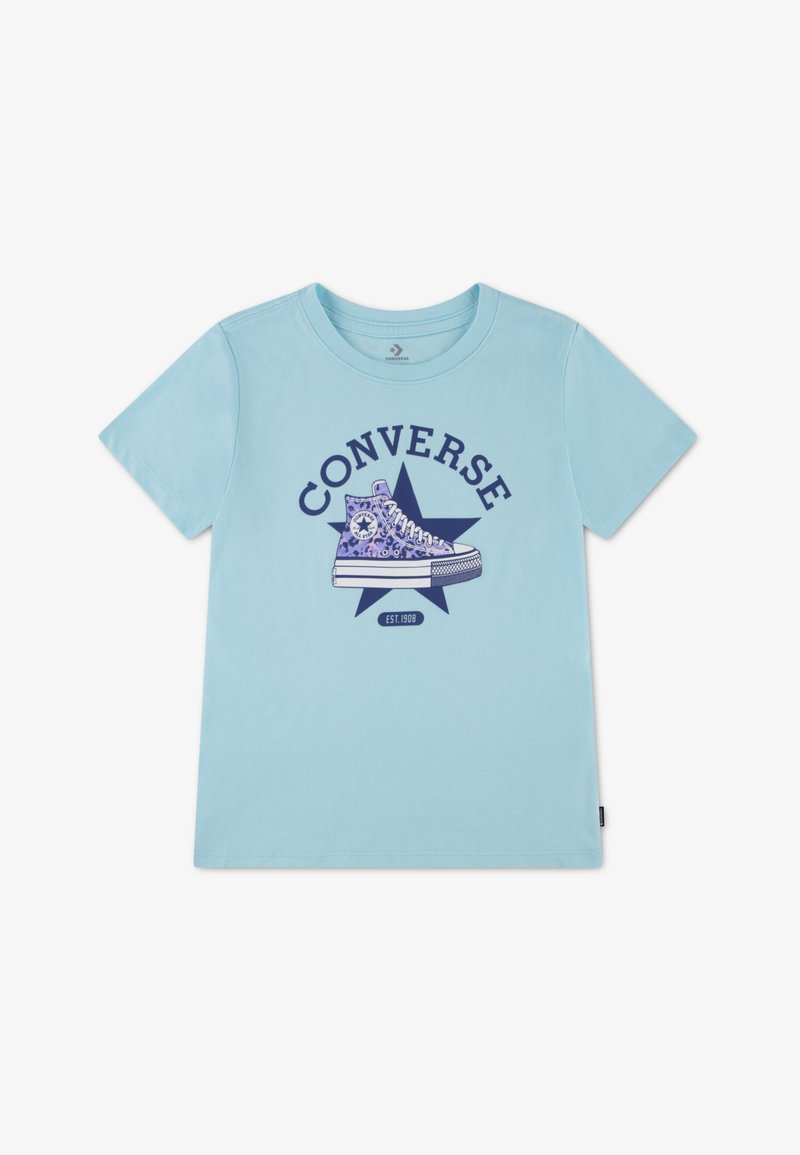 Hellblaues Baumwoll-T-Shirt mit einer lila Grafik eines Converse-Schuhs auf einem blauen Stern, darüber der Schriftzug "CONVERSE" und darunter "EST. 1908".