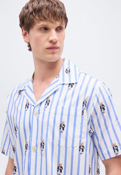 Πουκάμισο με κοντά μανίκια με κάθετες ρίγες σε μπλε και λευκό, με τσέπη και σχέδιο μικρών αρκούδων ντυμένες με κοστούμια.