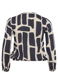 Long-sleeve blouse featuring a cream background with bold navy abstract brushstroke pattern, rounded neckline, and buttoned cuff details.